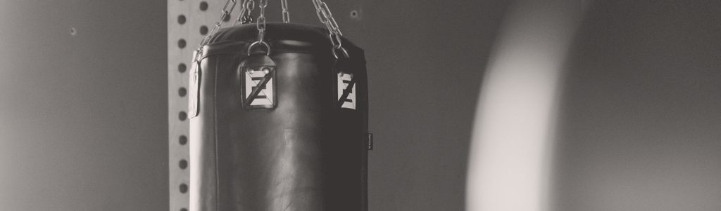 A leather heavy bag hanging still on its chains in an empty gym