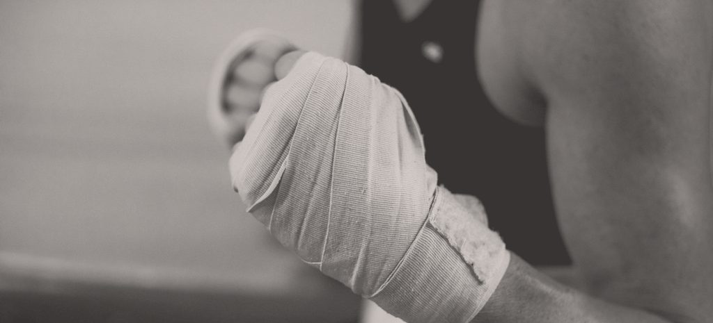 A boxer's hand wrapped in cotton, fist closed, forearm raised to guard height