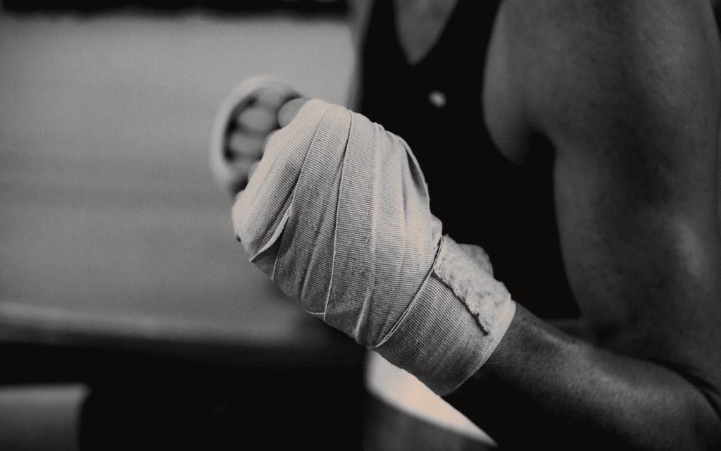 Close-up of a fist in a hand wrap, the boxer's body behind it