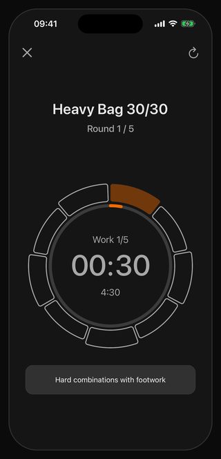 The Bell timer running Heavy Bag 30/30: round 1 of 5, work interval 1 of 5, 30 seconds left, the cue underneath reading Hard combinations with footwork